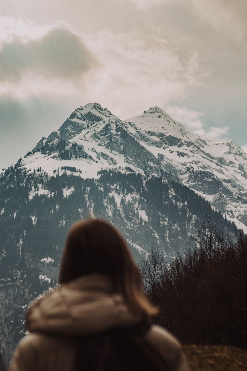 woman looking at snow covered mountain